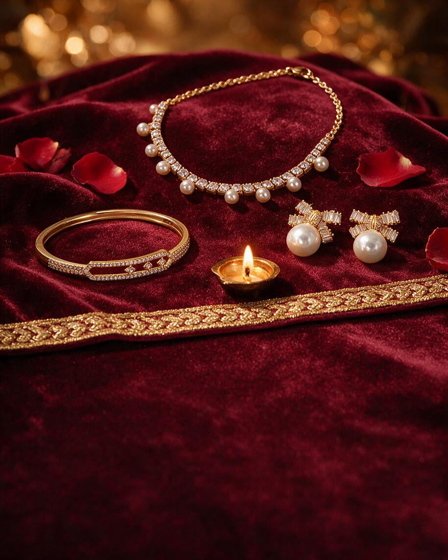 Pearl and crystal necklace, bow studs and a pave bangle on deep maroon velvet with gold zari, a diya and red rose petals