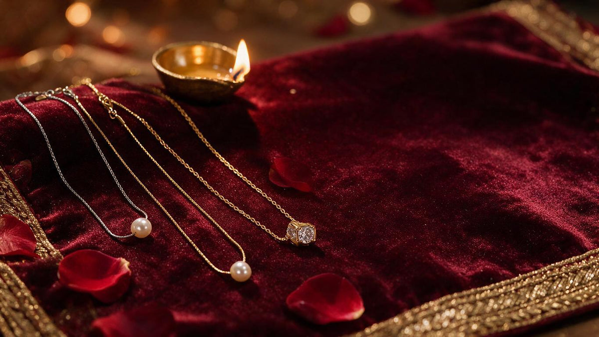 Dainty pearl and crystal pendant chains on deep maroon velvet with a brass diya and rose petals